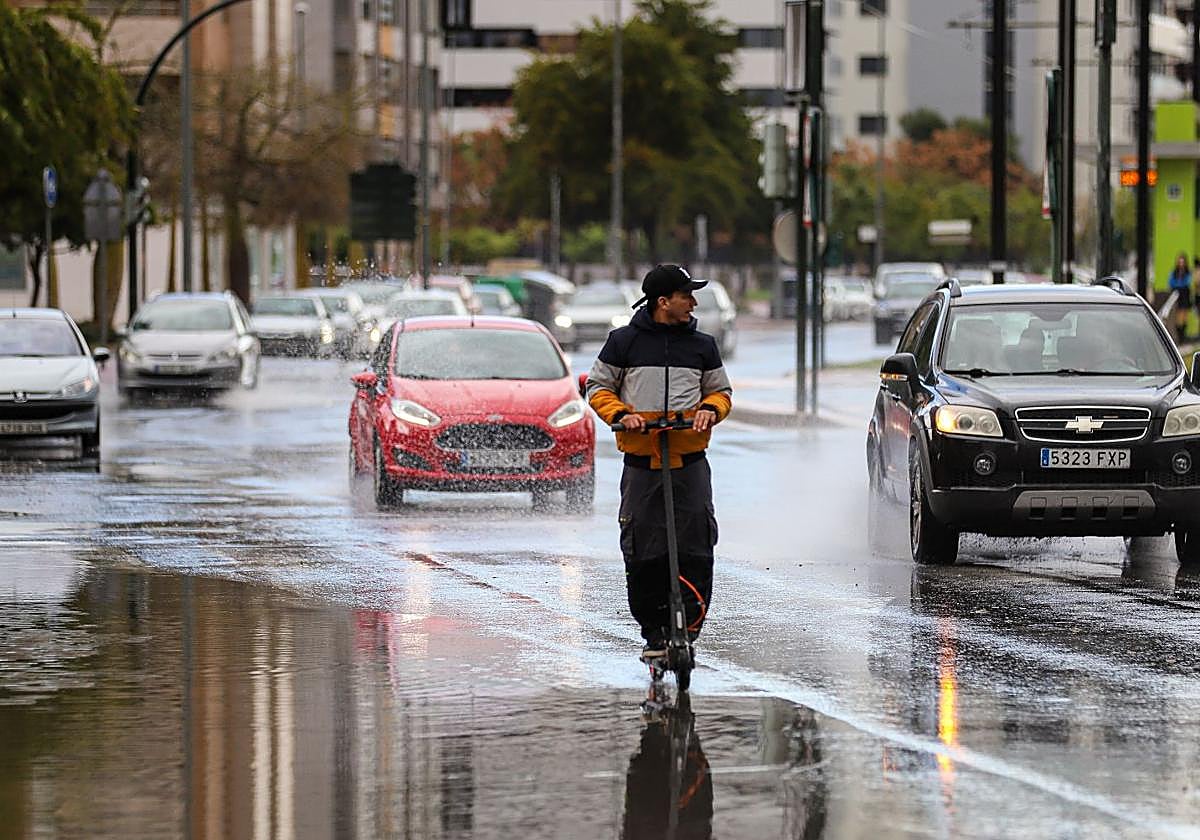 Un hombre circula en patinete en un día con lluvia en la ciudad de Murcia en una imagen de archivo