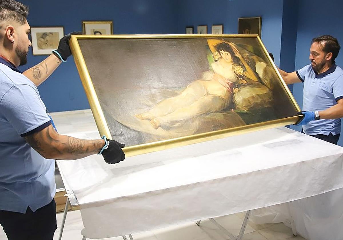 Dos operarios trasladan el cuadro de Gaya, ayer, desde su museo en Murcia.