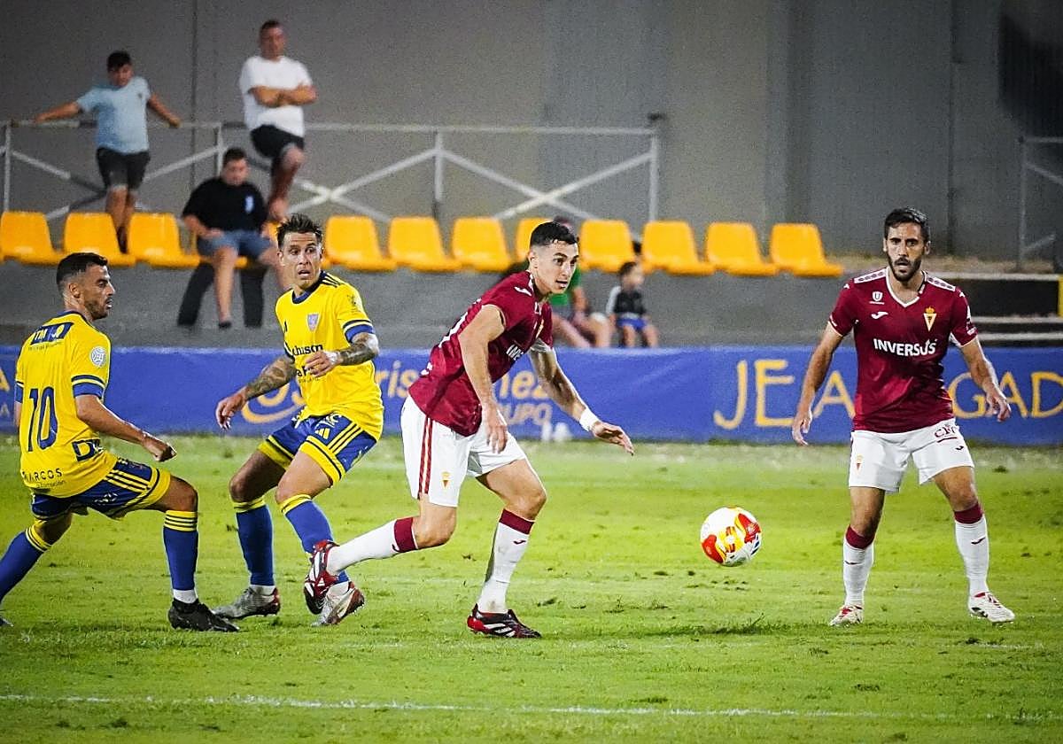 Antonio David, jugador del Real Murcia, juega un balón junto a su compañero Moyita en el amistoso de pretemporada ante el Orihuela.