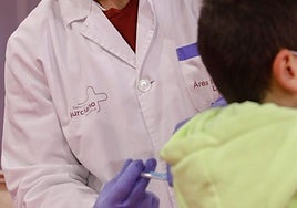 Un enfermero poniendo una vacuna a un niño, en una foto de archivo.