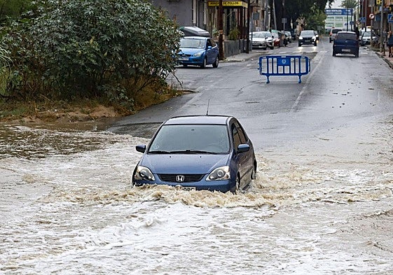 Un coche atraviesa el agua embolsada en la rambla del Secano de Torreagüera, en Murcia.