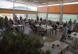 Fernando Sarasola explica el proyecto a los empresarios con las protestas vecinales al fondo.