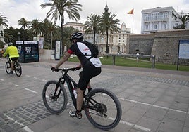 Un ciclista pasa frente a un puesto de alquiler fuera de servicio.