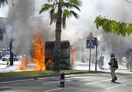El autobús, ardiendo, en la rotonda de entrada a la UCAM, en Murcia.