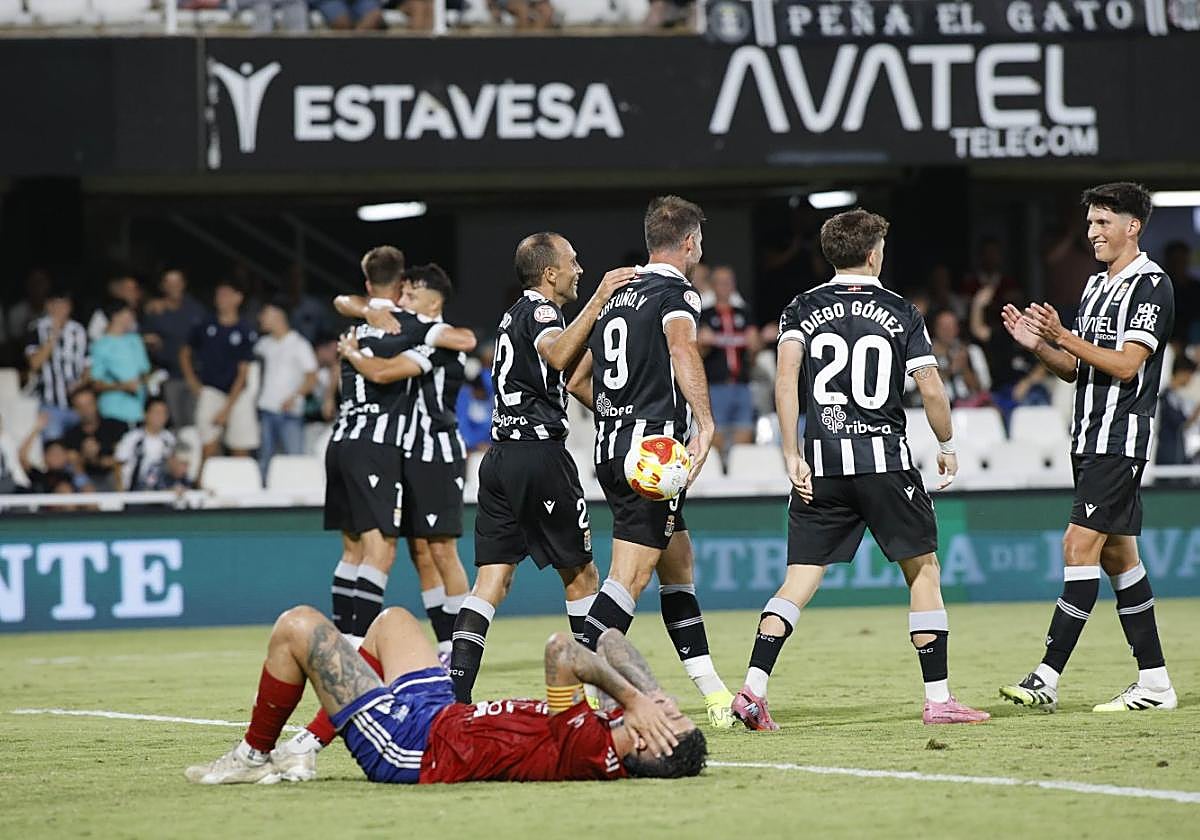 Trilles, capitán del Tarazona en el suelo, mientras los jugadores del Efesé celebran el gol de Ortuño, que volvió a celebrar uno tras 17 meses de sequía en liga.