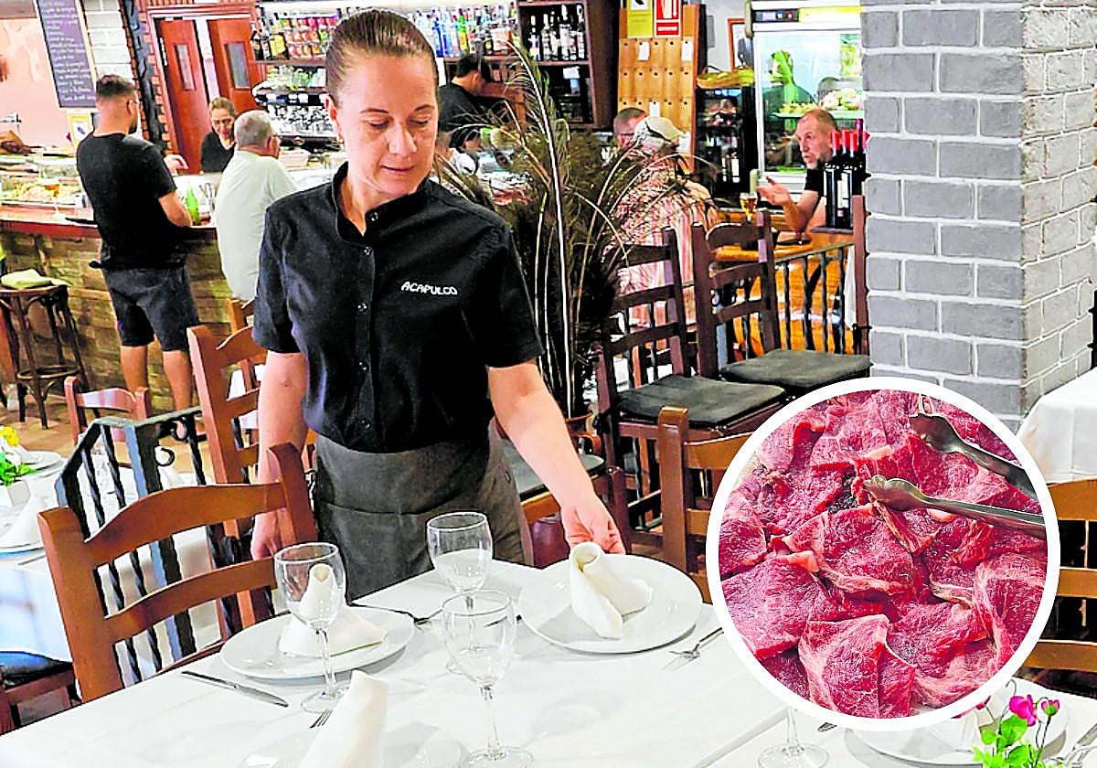 Una de las camareras prepara las mesas en el comedor del restaurante.