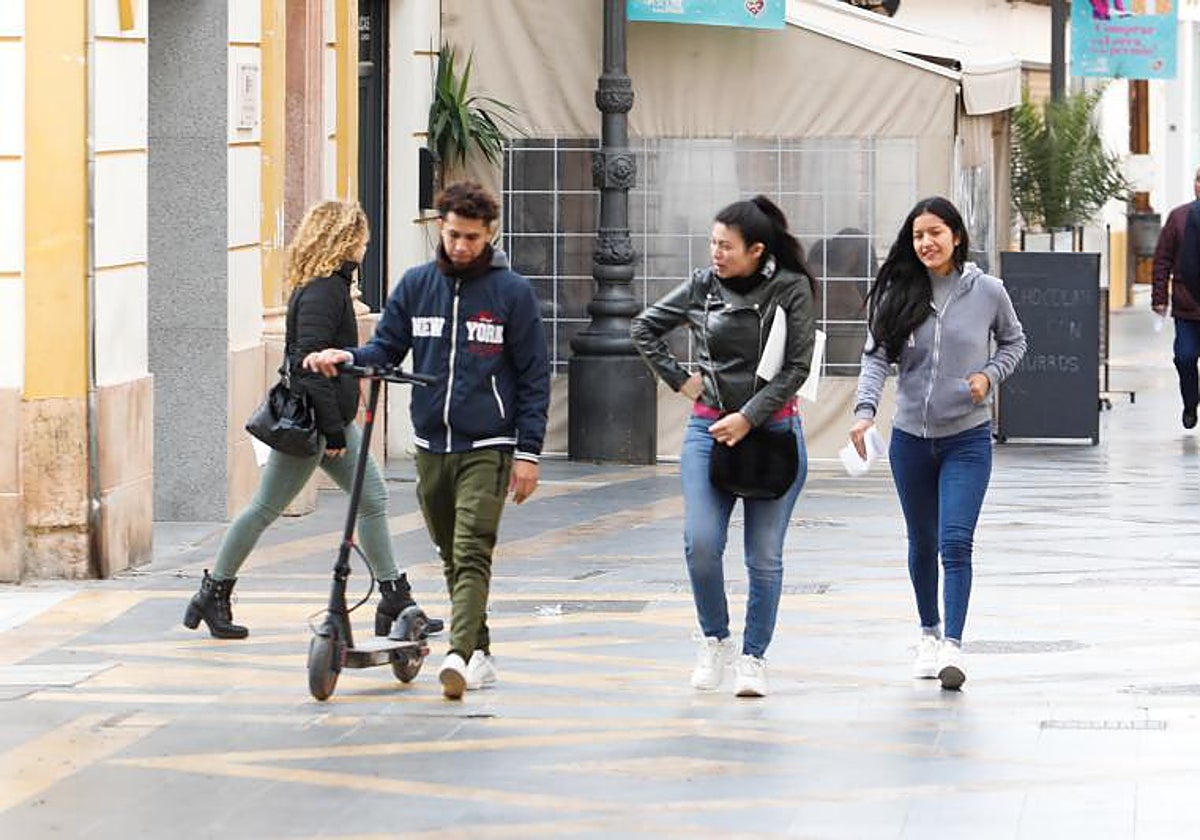 Un joven camina con un patinete en la calle Corredera, en una imagen de archivo.