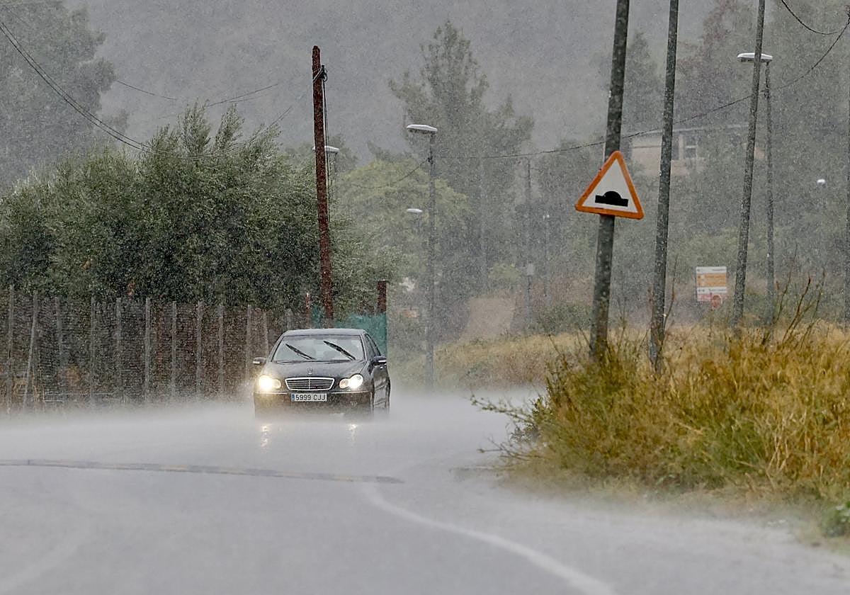 Un vehículo circula bajo la lluvia, en el este del municipio de Murcia.