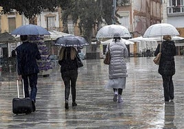 Cuatro viandantes en Cartagena en un día de lluvia.