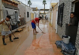 Vecinos de Los Alcázares se afanan en retirar el barro de sus viviendas, este sábado.