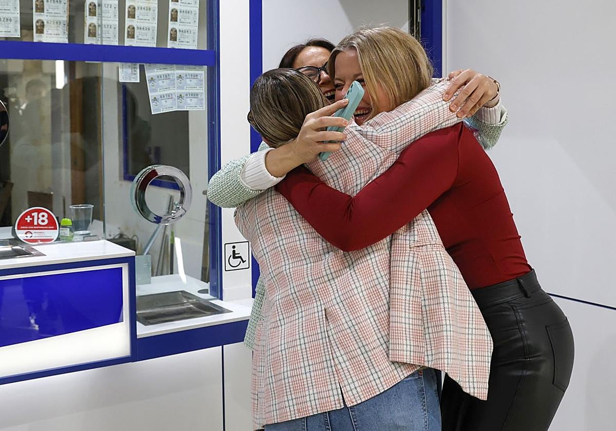 Tres mujeres se abrazan para celebrar un premio de la Lotería de Navidad.