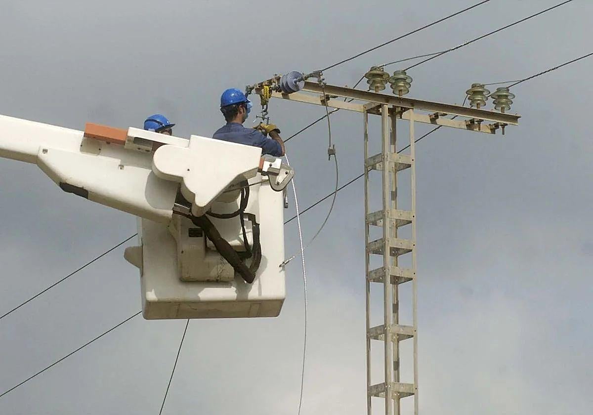 Un trabajador realiza una reparación en un cable de alta tensión.