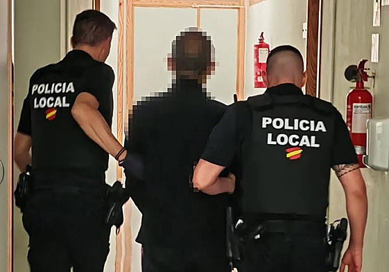 Dos policías locales escoltan al detenido.