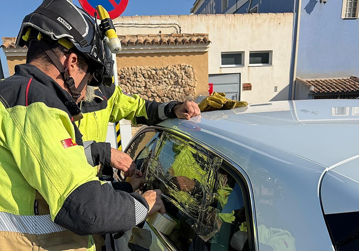 Los bomberos, este sábado, trabajando para abrir el coche.