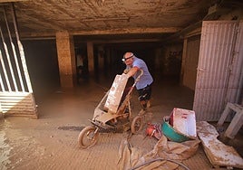 Un vecino sacando este sábado objetos de un trastero anegado de barro en la avenida Virgen de Loreto, en San Javier.