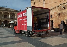Operarios cargan en el camión de mudanza el mobiliario de la oficina de turismo de la plaza de España.