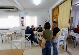 Técnicos municipales atienden la consulta de un vecino en el local social de Cazalla, mientras otros esperan su turno.