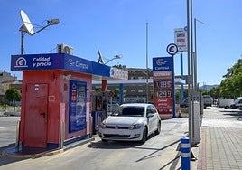 Un coche preparado para repostar en una estación de servicio automática, ayer, junto a otra de bajo coste en la zona de Juan Borbón, en Murcia.