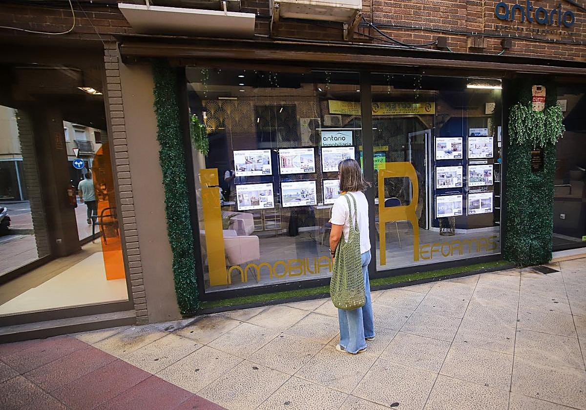 Una mujer consulta la oferta en una inmobiliaria de Murcia, ayer.