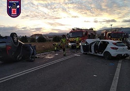 Los bomberos trabajando en la zona con los dos vehículos accidentados.