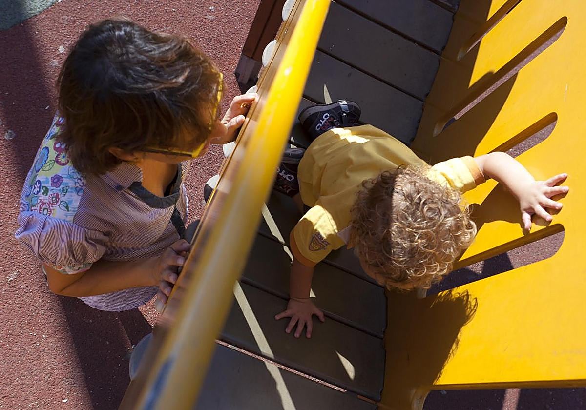 Una madre soltera juega con su hijo en un parte.