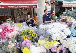 Elisa Martínez y su compañero preparan dos arreglos florales para el Día de Todos los Santos.