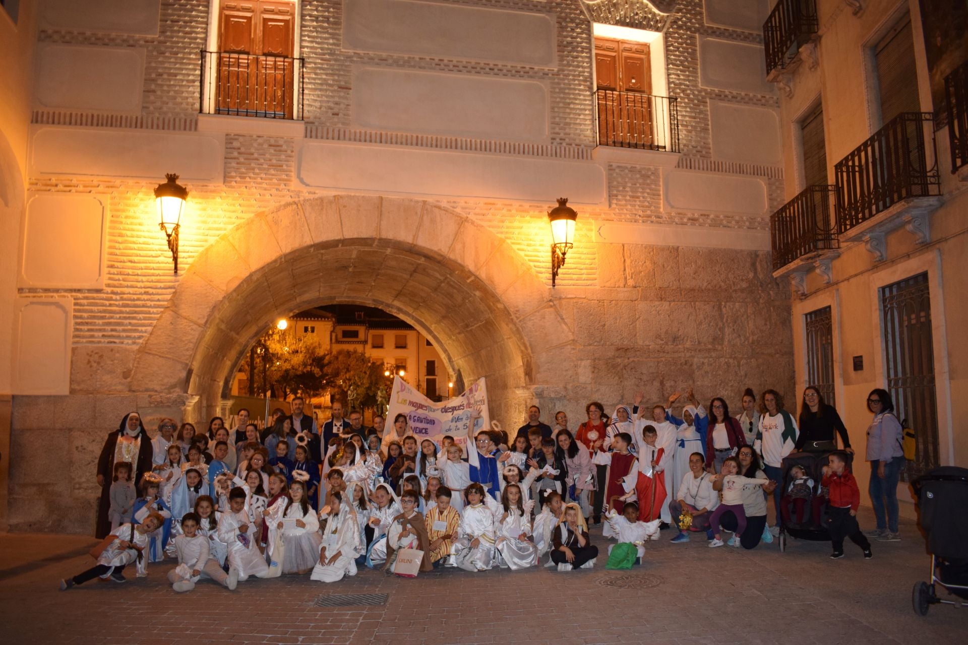 Losa niños junto a catequistas y familiares junto al arco del Ayuntamiento.