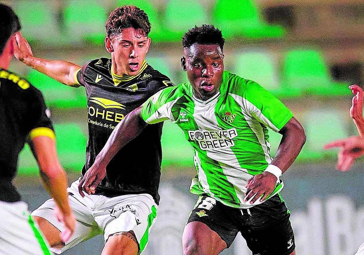 Mawuli, del Betis Deportivo, conduce la pelota entre varios jugadores del Atlético Sanluqueño.