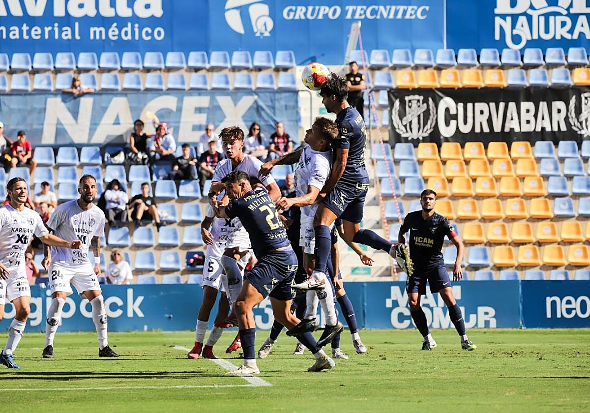 Jugadores del UCAM y el Yeclano pugnan por un balón tras una falta lateral.
