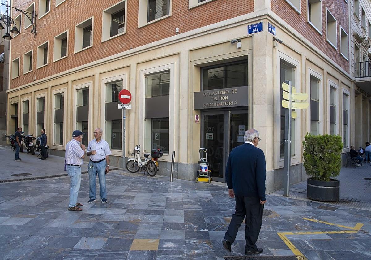 Grupos de cartageneros deambulan frente a la oficina municipal de gestión recaudatoria, ubicada en la sede administrativa de la calle San Miguel.