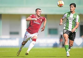 David Flakus, delantero del Real Murcia, persigue un balón ante Moha, defensa del Betis Deportivo, en el partido del pasado fin de semana.