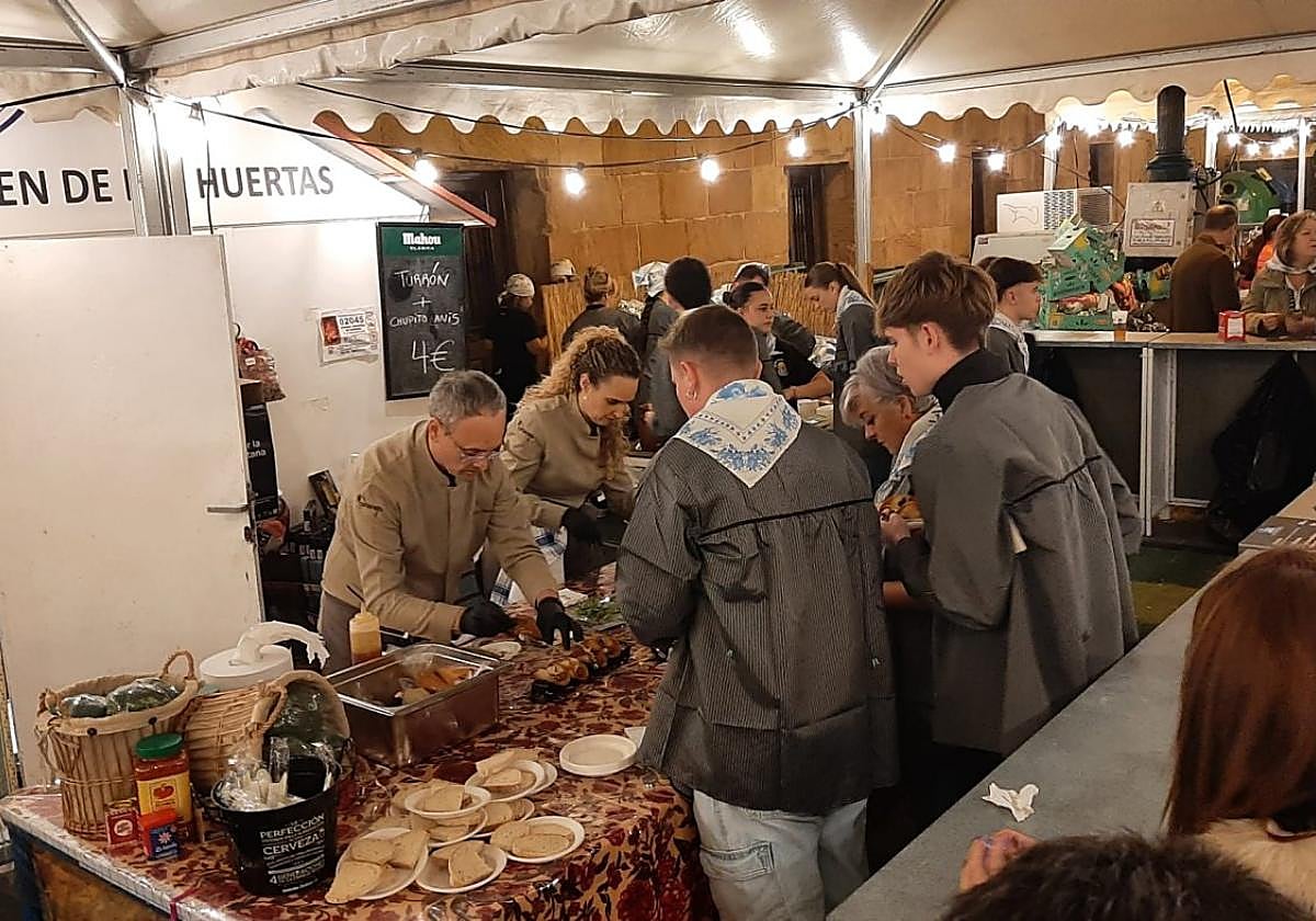Cocineros preparan las tapas en la feria La Huertana, en la plaza de España llena de público, anoche.