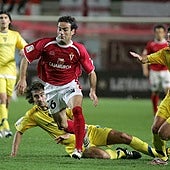 Paco Peña conduce el balón perseguido por Pablo Hernández y Fleurquin (en el suelo), en el Real Murcia-Cádiz de la temporada 2006-07.
