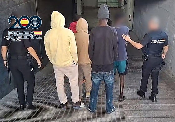 Dos agentes de la Policía Nacional junto con los detenidos.