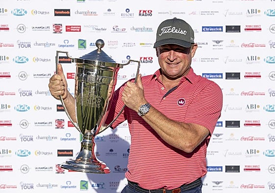 El feliz campeón, James Donaldson, sujetando su trofeo.