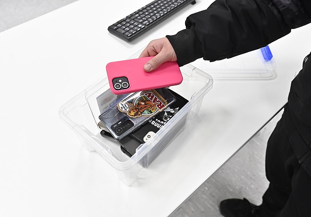 Los alumnos dejan sus móviles en un recipiente en una imagen de archivo.