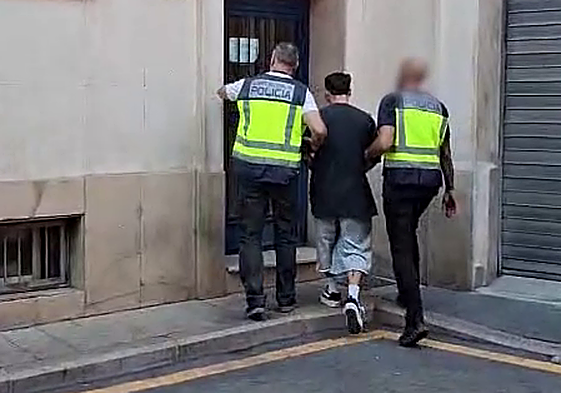 Dos agentes conducen al arrestado a dependencias policiales.