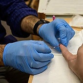 Un enfermero toma una muestra para un test rápido de VIH.