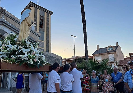 Un vecino pasea con su bici frente a la iglesia de Los Urrutias, este miércoles.