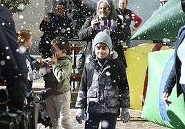 Eiden Moreno, al centro, rodeado de vecinos, durante la caída de nieve artificial en Torreagüera.
