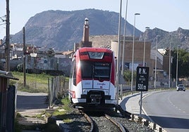 Un convoy del FEVE circula junto a la carretera de La Unión.