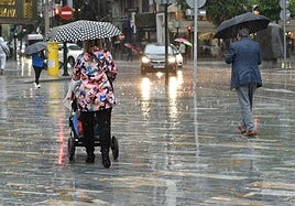Dos pasean caminan bajo la lluvia en Murcia en una imagen de archivo.