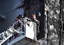 Bomberos comprueban la parte de la fachada afectada por las llamas.