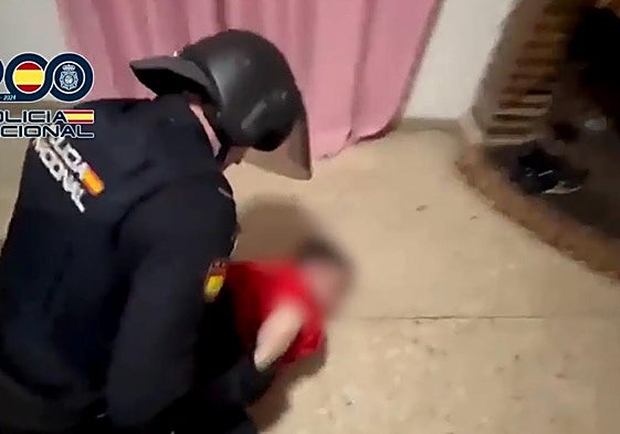 Un policía nacional engrilleta en el suelo a uno de los tres detenidos en la redada del pasado 19 de noviembre.