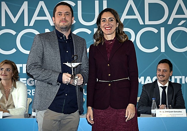 El colegiado Jesús Gnecco recogiendo el premio de manos de la decana del COFRM, Paula Payá.