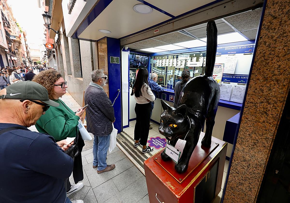 Cola para comprar Lotería de Navidad en la administración El Gato Negro, en Murcia.