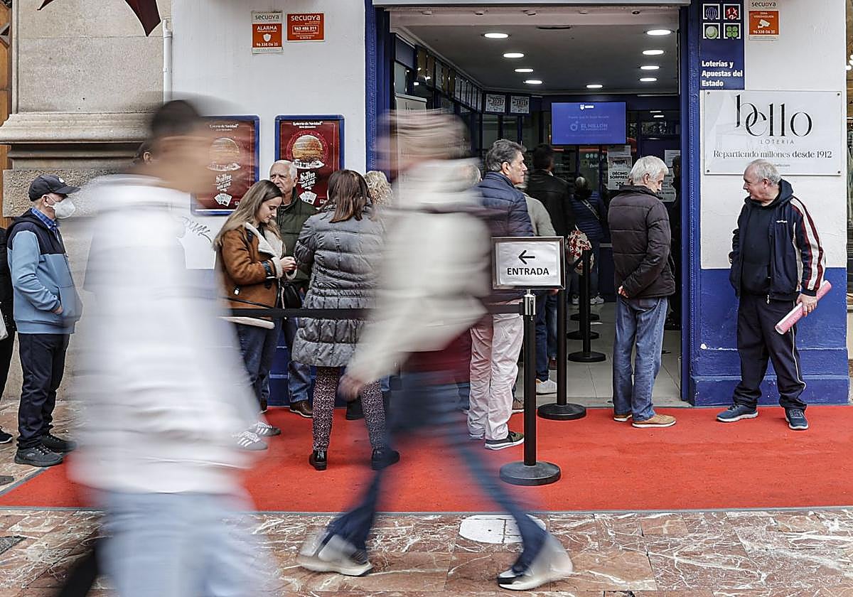 Ciudadanos hacen cola para adquirir sus décimos de la Lotería de Navidad.