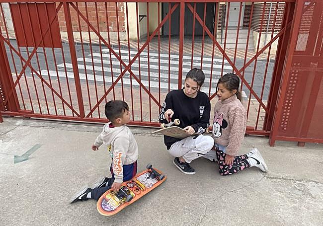 La voluntaria Lucía Nicolás, con dos niños en el CEIP Francisco Salzillo de Los Ramos.