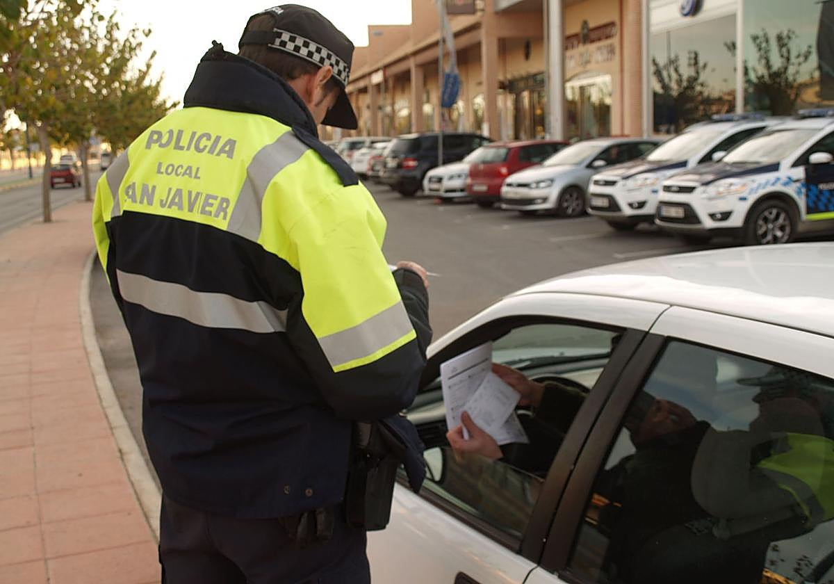 Un agente de la Policía Local de San Javier revisa la documentación de un conductor durante un control rutinario de tráfico.