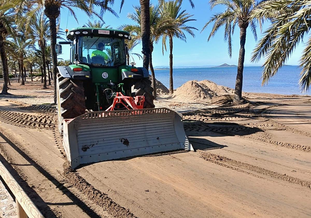 Un operario trabaja para poner a punto la arena en la playa Villas Caravaning.